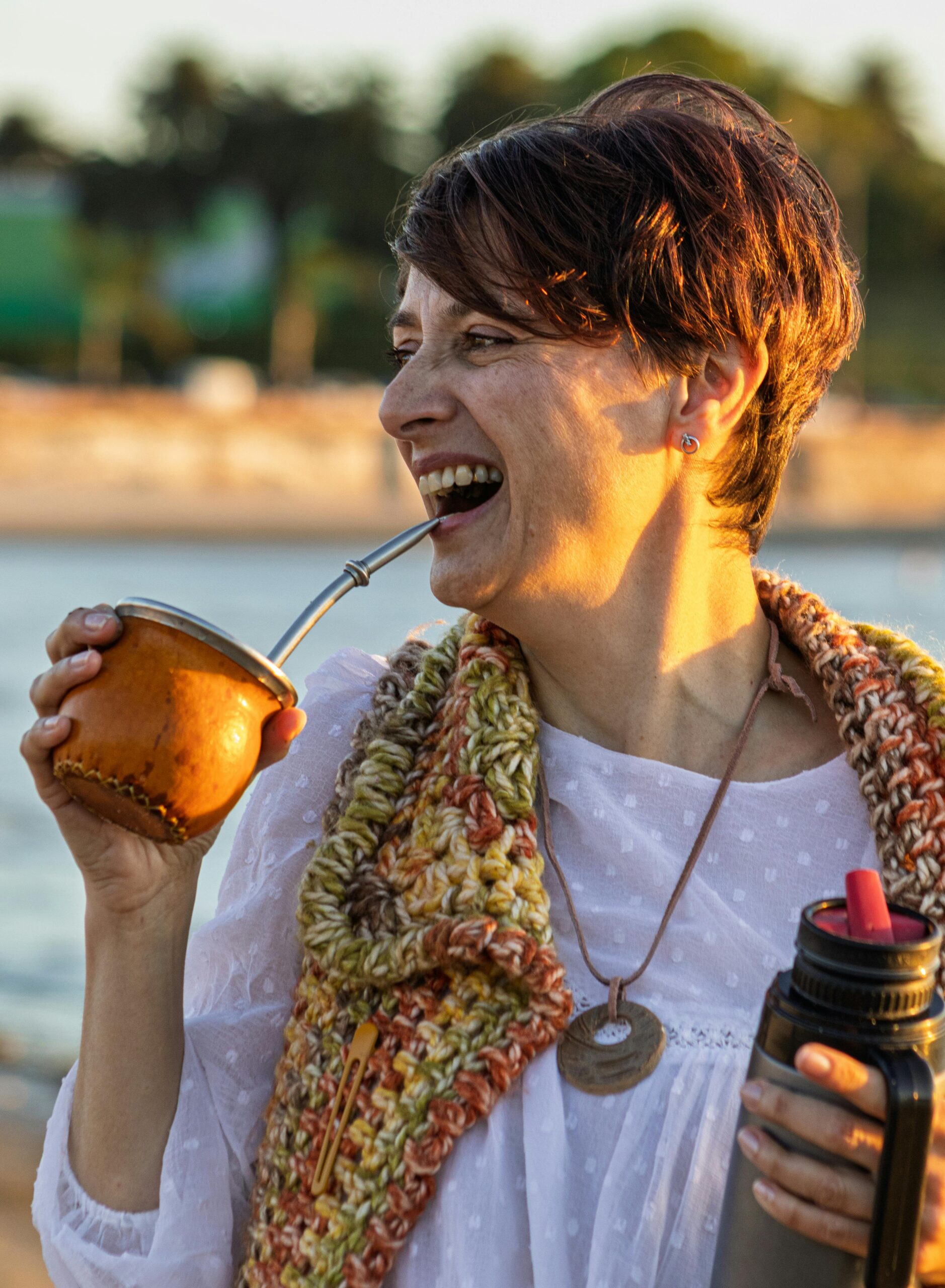 Adult woman drinking yerba mate on a sunny beach in Montevideo, Uruguay.